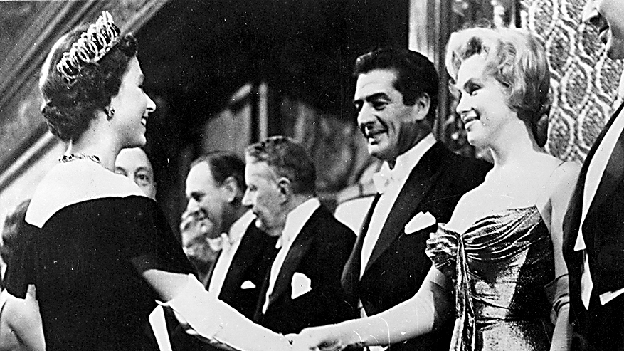 Queen Elizabeth II shaking hands with Marilyn Monroe (1926 - 1962) who stands next to Victor Mature (1913 - 1999) at a Royal Film Performance of 'The Battle of the River Plate' at the Empire Theatre, Leicester Square, London. 