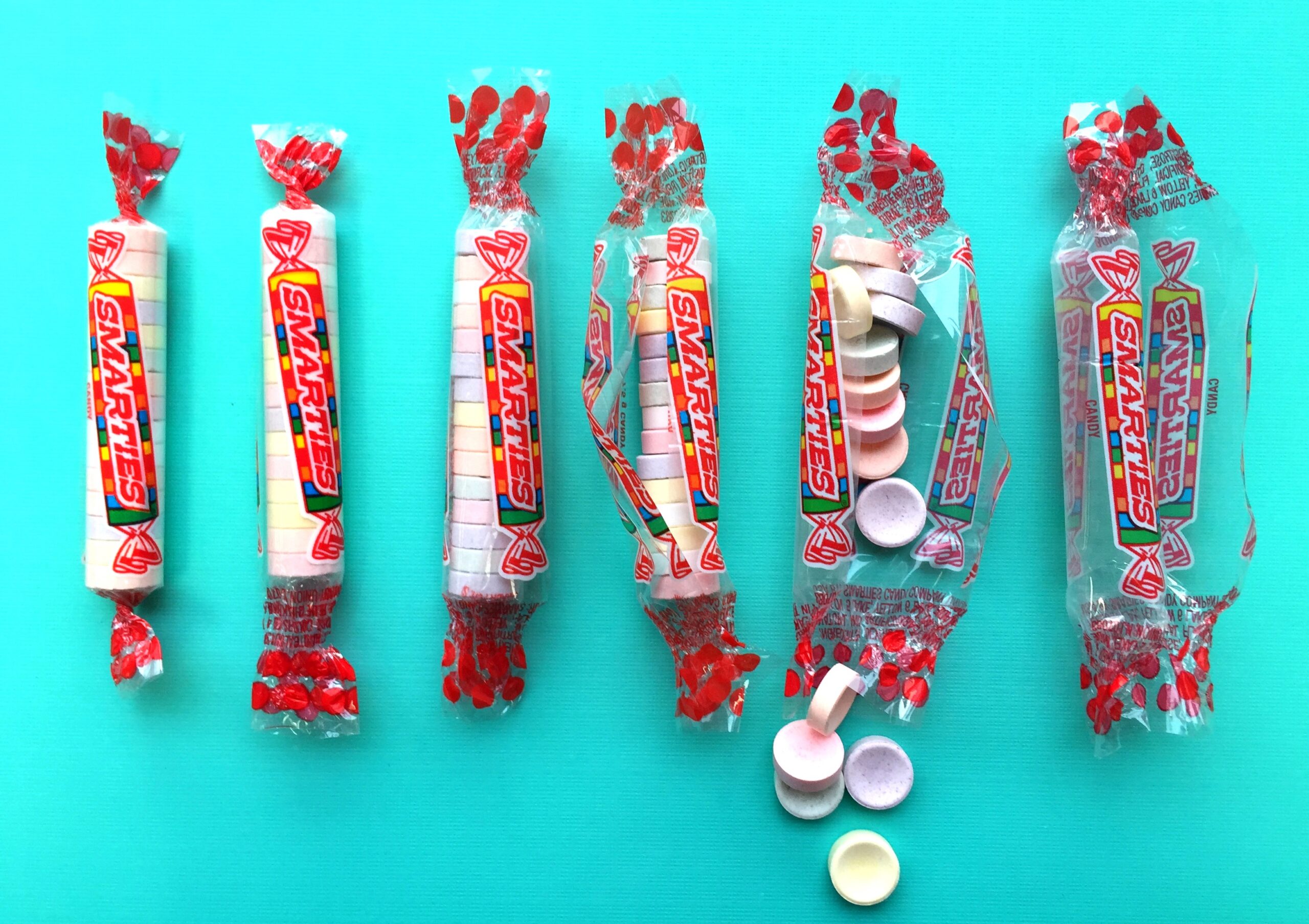 Smarties candy rolls on blue background.